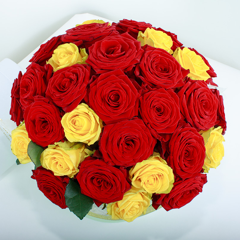 Фото Красные и желтые розы в зеленой коробке
